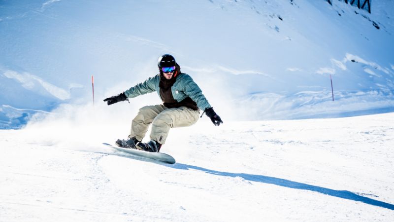 A man riding a snowboard down a snowy slope.