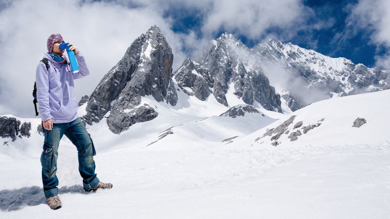 Male climber breathing with mini portable oxygen to avoid and treat altitude sickness.