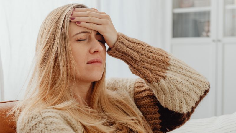 A woman holding her head in pain.