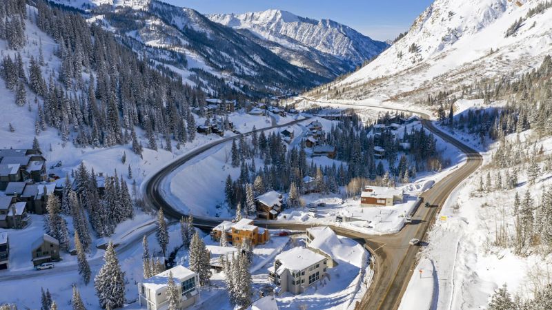 Aerial view of a winding road through a snowy mountain neighborhood in Alta, Utah.